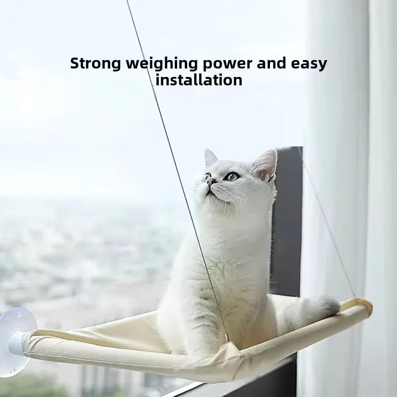 A cat sitting on the khaki hammock mounted to a window