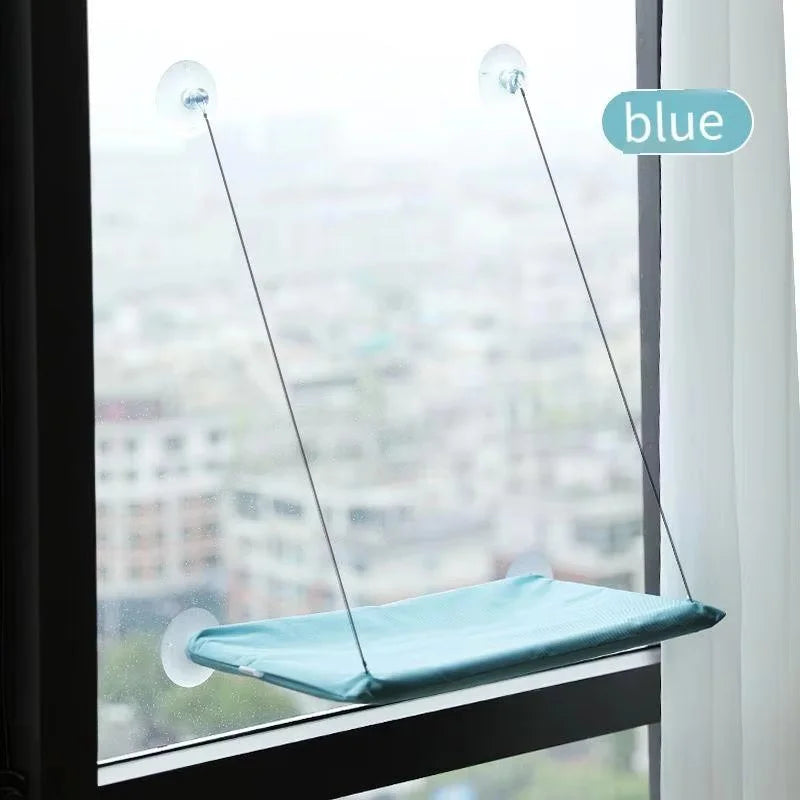 The hammock in light cyan, mounted on a window