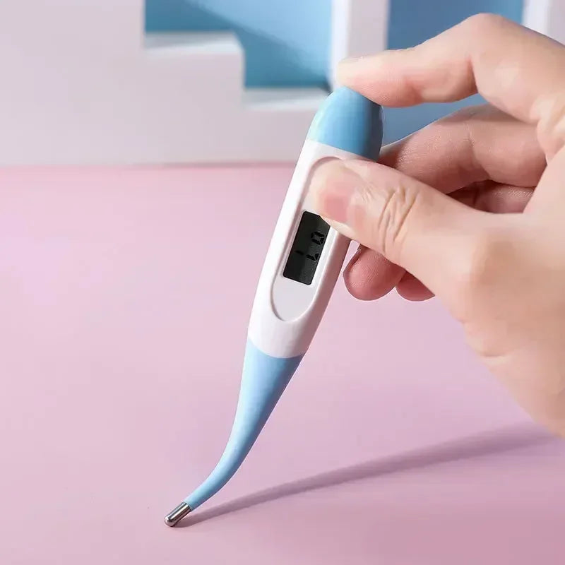 Hand holding a blue and white digital pet thermometer with LCD display and flexible metal probe tip
