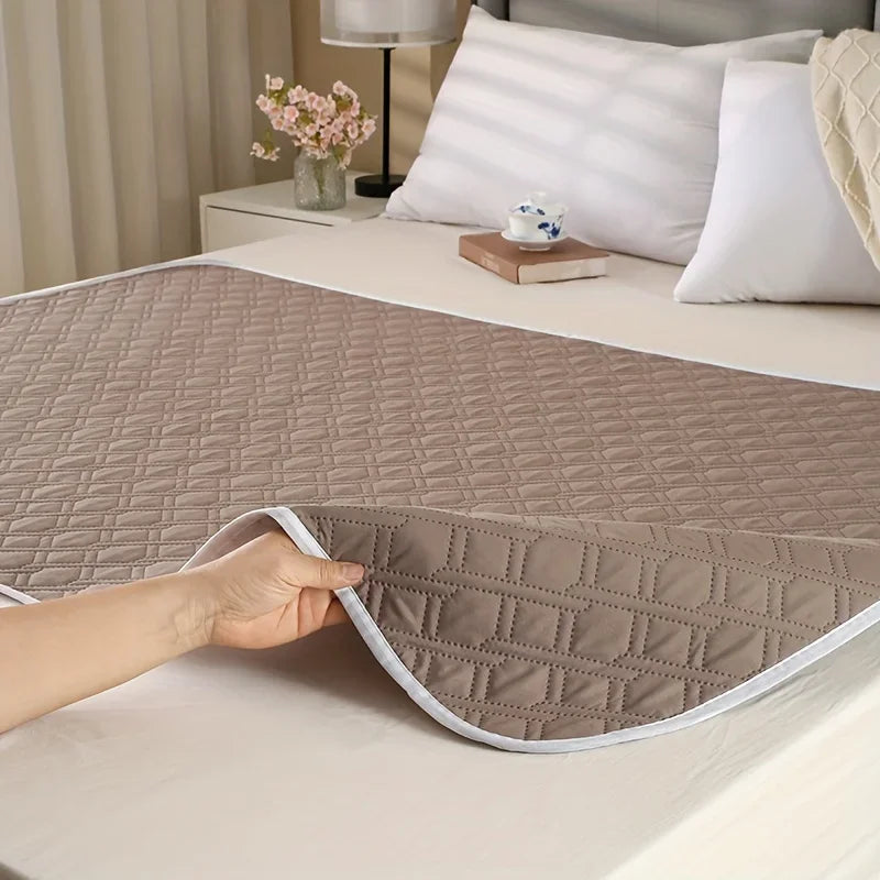 Brown quilted dog bed mat with flexible padded construction and diamond-patterned surface shown on a bed