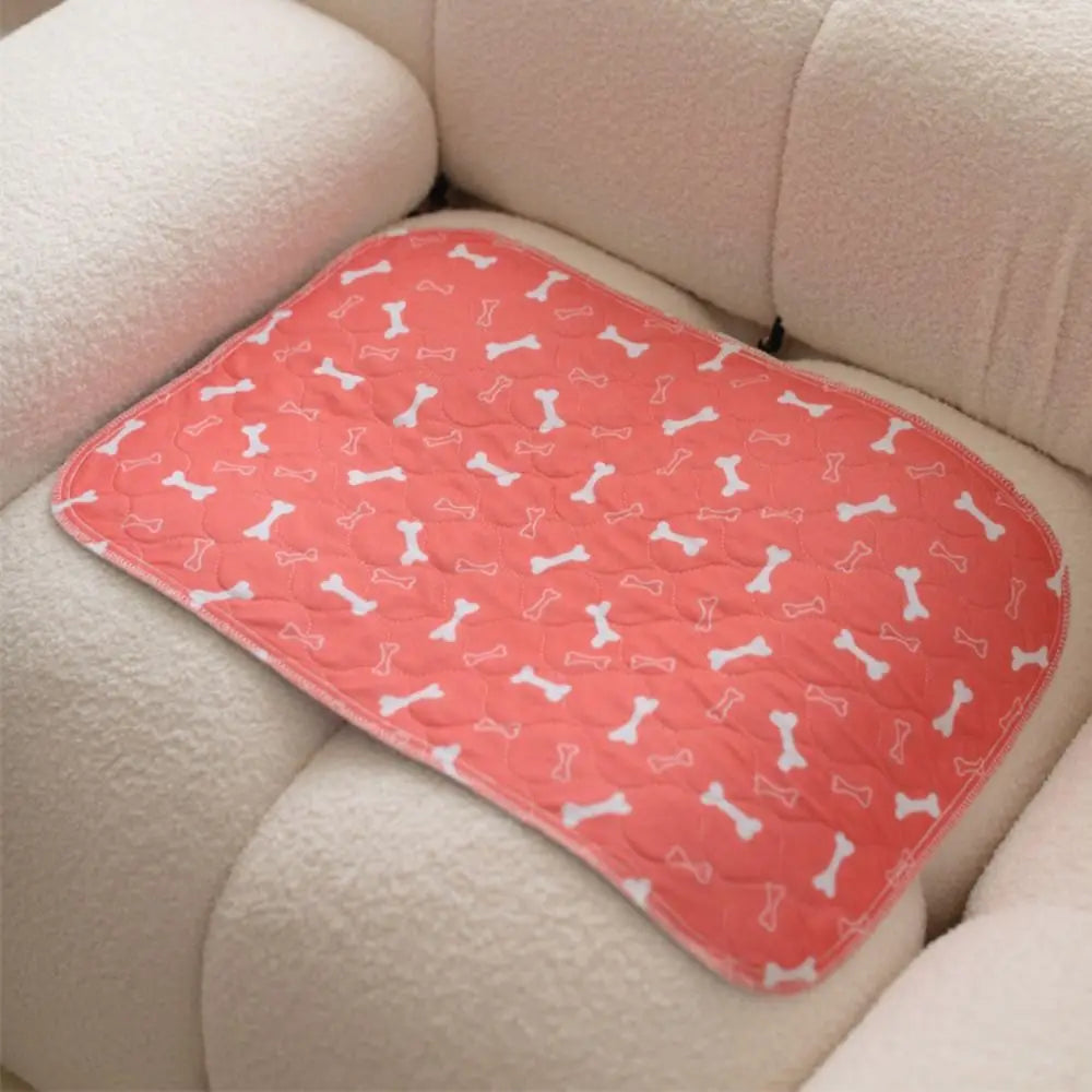 Beige rectangular dog bed mat with black paw print and bone pattern and rounded corners