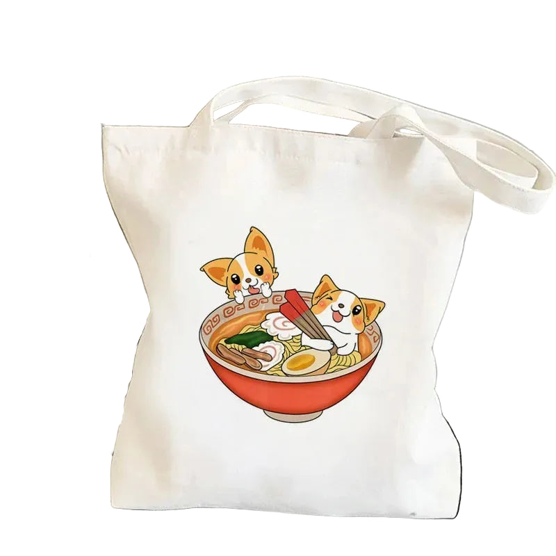 Cream canvas tote bag featuring two cartoon Corgis in a bowl of ramen with noodles, egg and vegetables