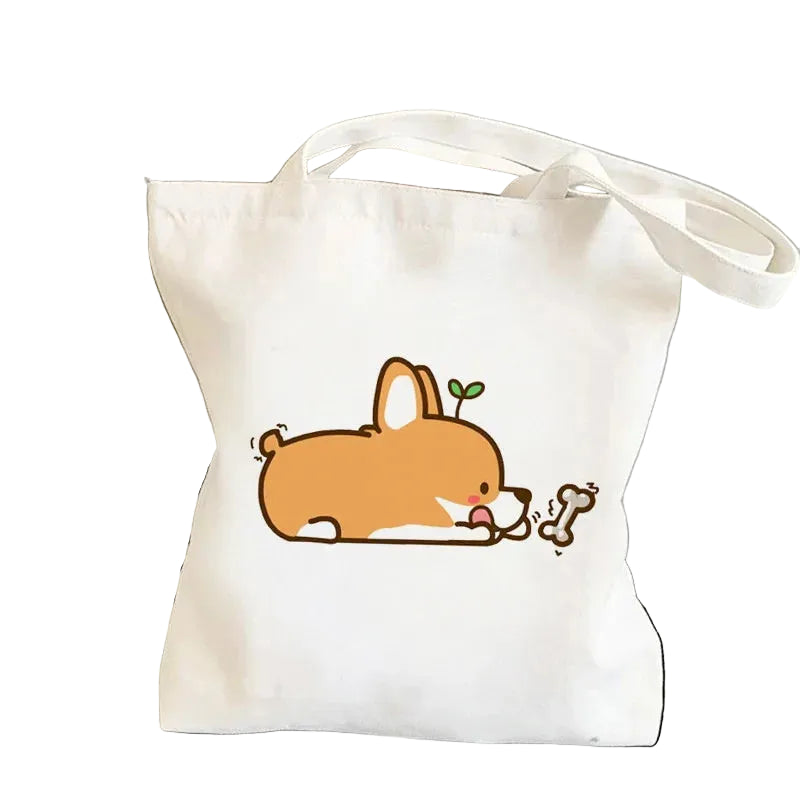 Cream canvas tote bag featuring a cute cartoon Corgi chewing a bone
