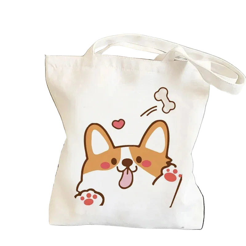 Cream canvas tote bag featuring a cute cartoon Corgi with raised paws, a heart and a flying dog bone