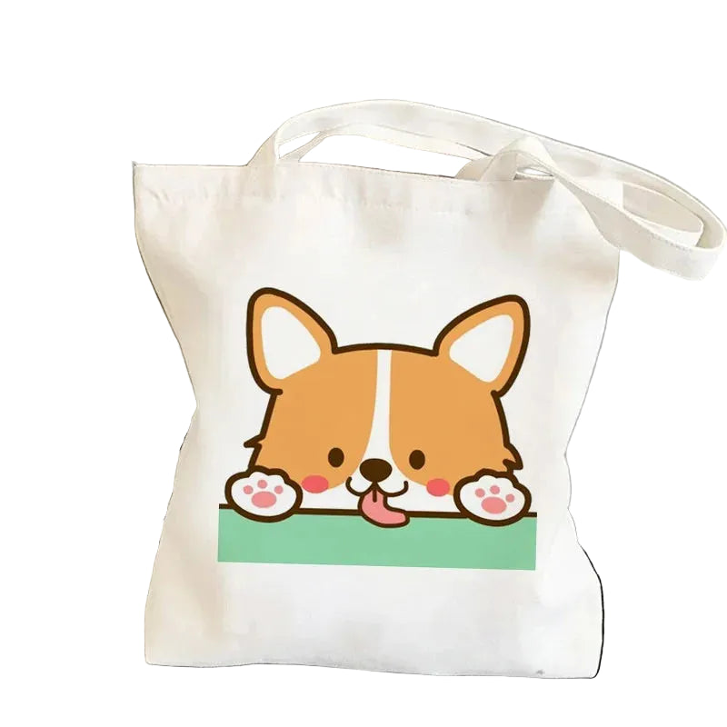 Cream canvas tote bag featuring a cute cartoon Corgi peeking over a green edge with its paws visible