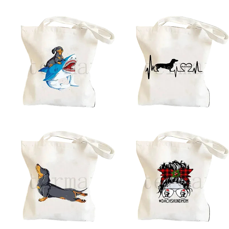 Collection of four cream canvas tote bags featuring Dachshund graphics, including shark rider, heartbeat, stretching dog and Dachshund Mom designs