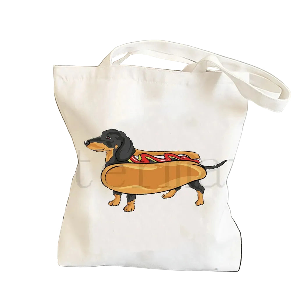 Cream canvas tote bag featuring a black and tan Dachshund dressed as a hot dog with mustard