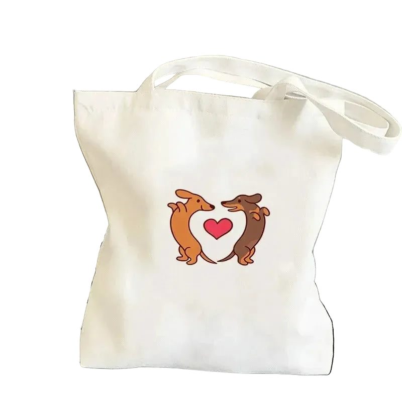 Cream canvas tote bag featuring two Dachshunds forming a heart shape around a red heart graphic