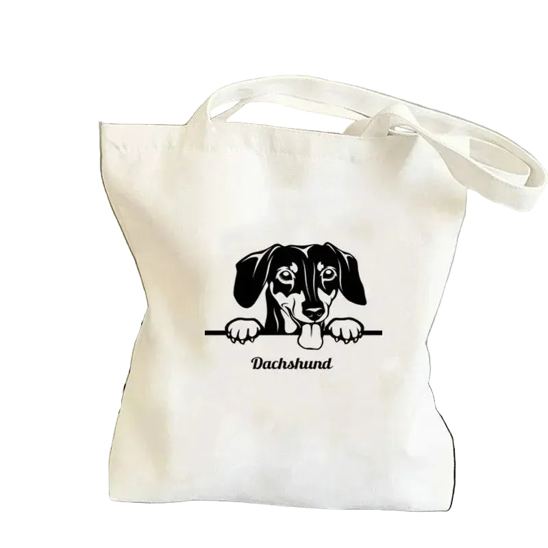 Cream canvas tote bag featuring a black Dachshund peeking over a line with the word Dachshund below