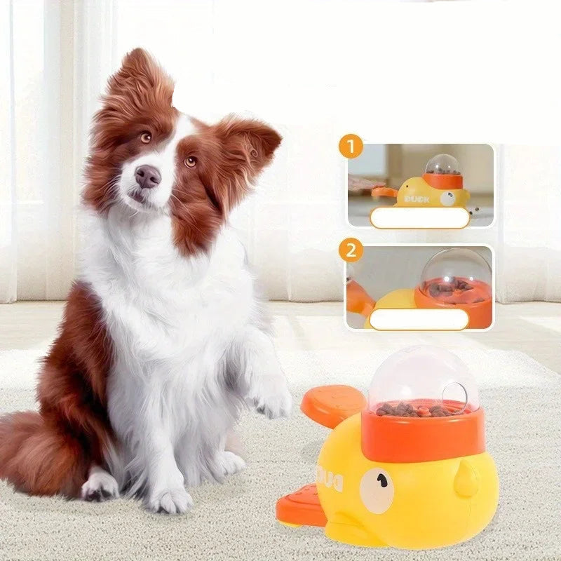 Dog beside a duck-shaped interactive food dispenser with kibble and paw-operated feeding lever
