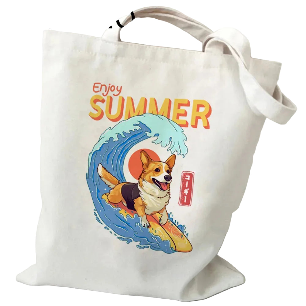 Cream canvas tote bag featuring a surfing Corgi riding a wave with the words Enjoy Summer