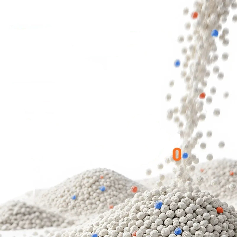 Fine bentonite clumping cat litter granules being poured into a pile for use in a cat litter tray