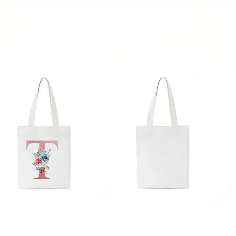 Front and back view of a cream canvas tote bag featuring a floral letter T design on one side