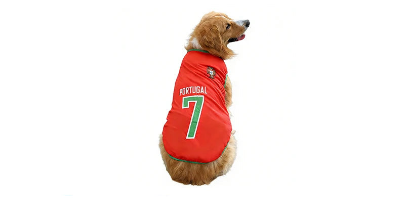 Golden-coloured dog wearing a red Portugal soccer jersey with green trim and number 7 on the back