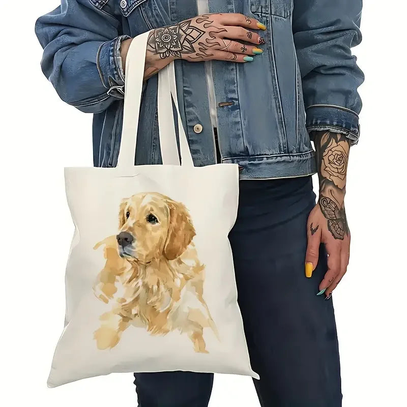 Person carrying a cream canvas tote bag featuring a watercolour-style Golden Retriever portrait