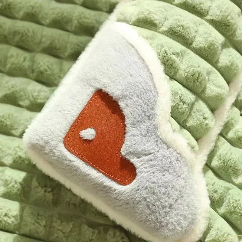 Close-up of green quilted dog bed mat with soft plush raised pillow and decorative patch detail