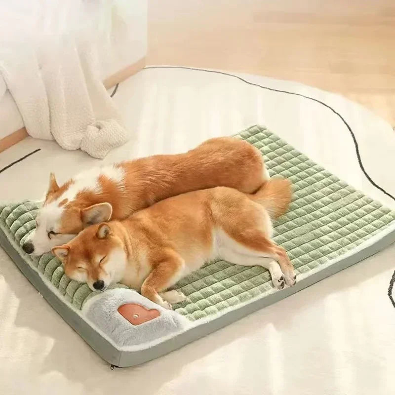 Two dogs sleeping on a green quilted dog bed mat with a soft padded surface and raised pillow support