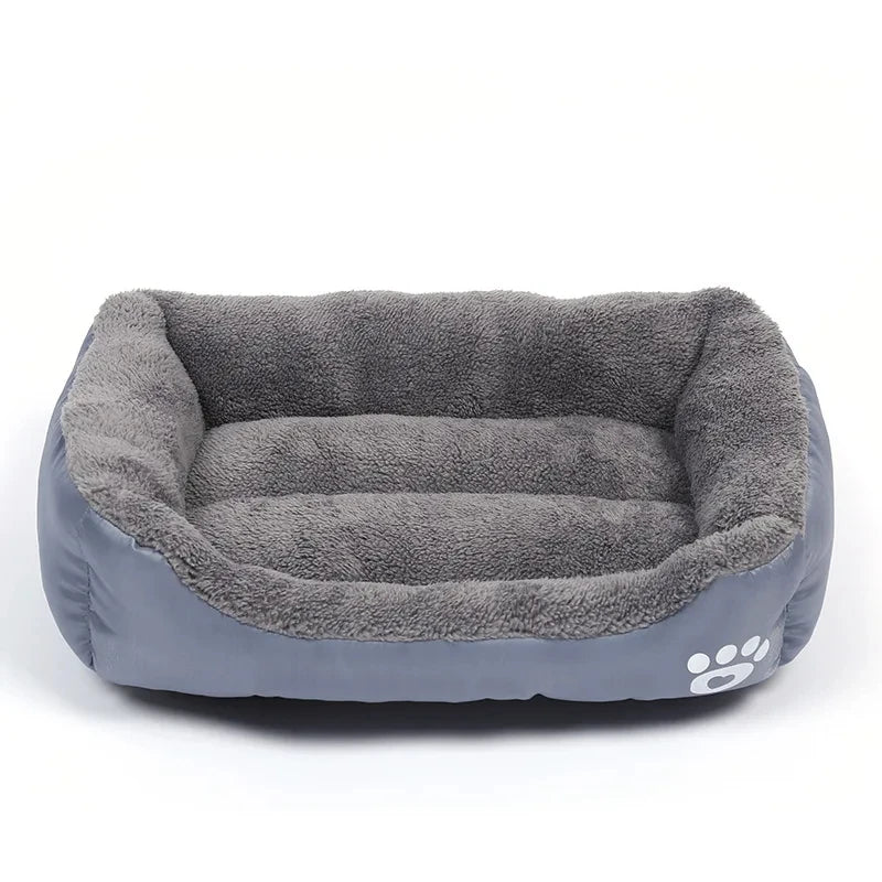 Grey plush bolster dog bed with soft padded base, raised cushioned sides and paw print detail