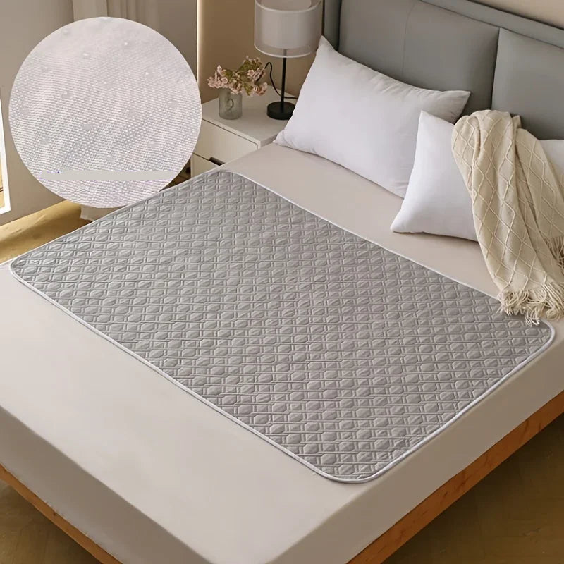 Grey quilted dog bed mat with a soft padded diamond-patterned surface placed on a bed