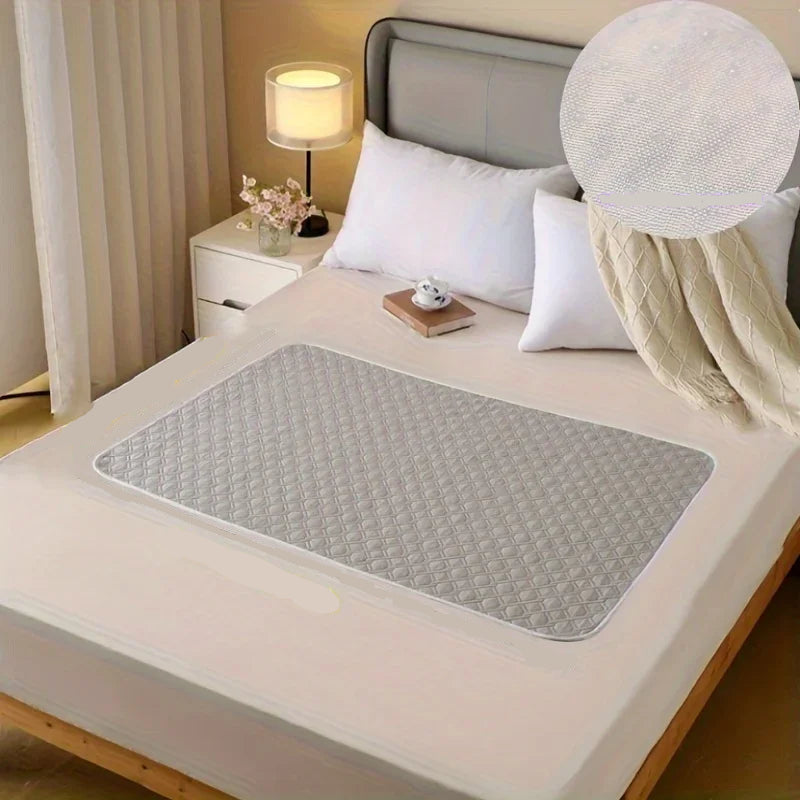 Grey quilted dog bed mat with padded diamond-pattern surface placed on a bedroom bed
