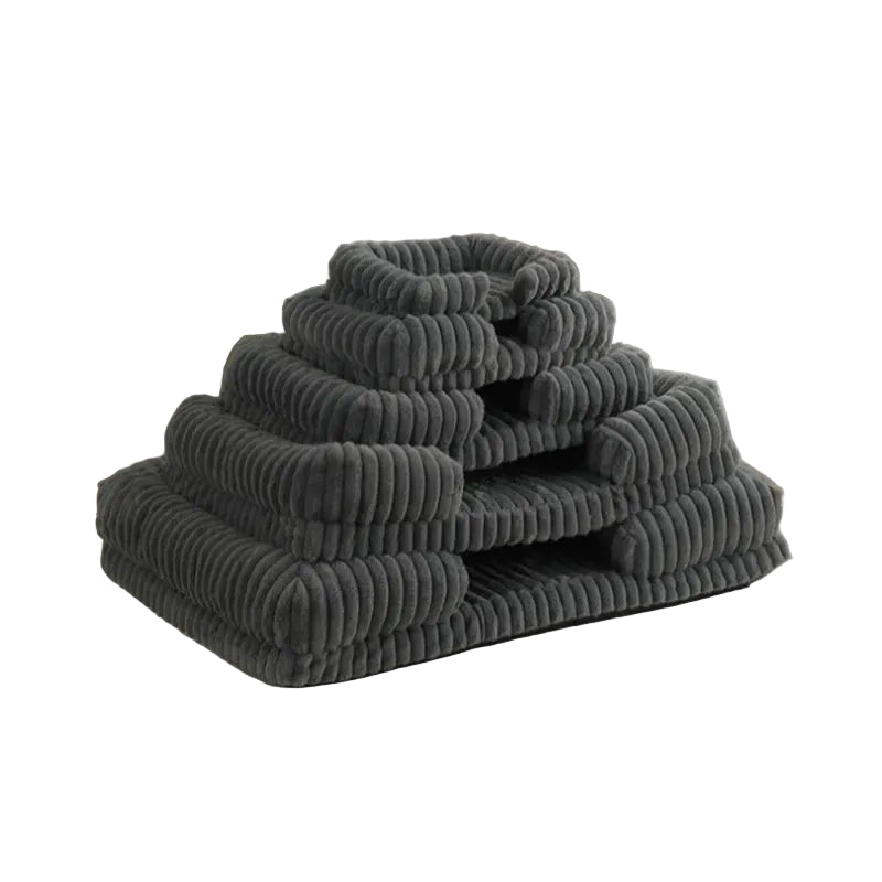 Stacked grey ribbed dog beds in multiple sizes with soft padded bases and raised bolster sides