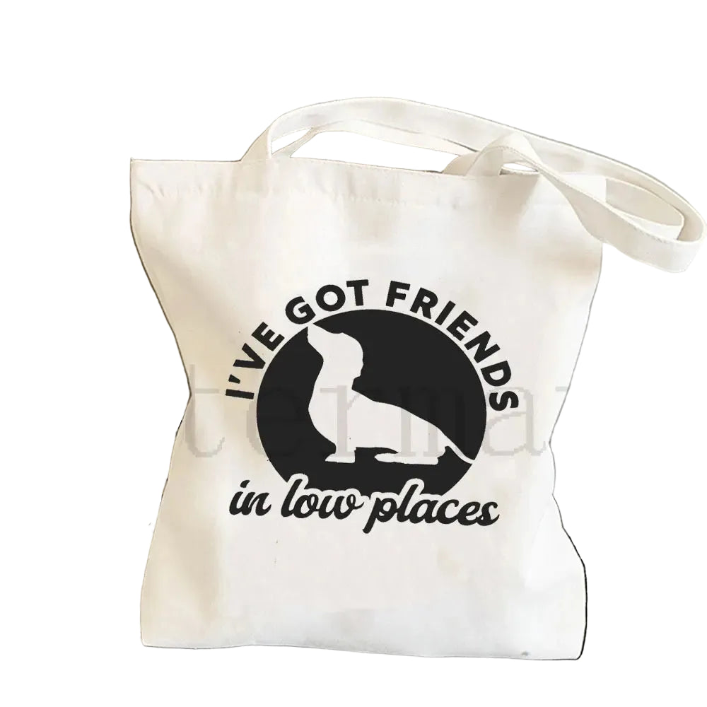 Cream canvas tote bag featuring a Dachshund silhouette with the phrase I've Got Friends in Low Places