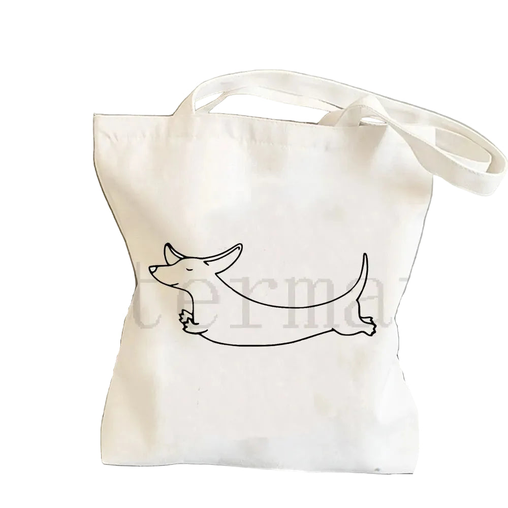 Cream canvas tote bag featuring a black and tan Dachshund riding a blue shark illustration