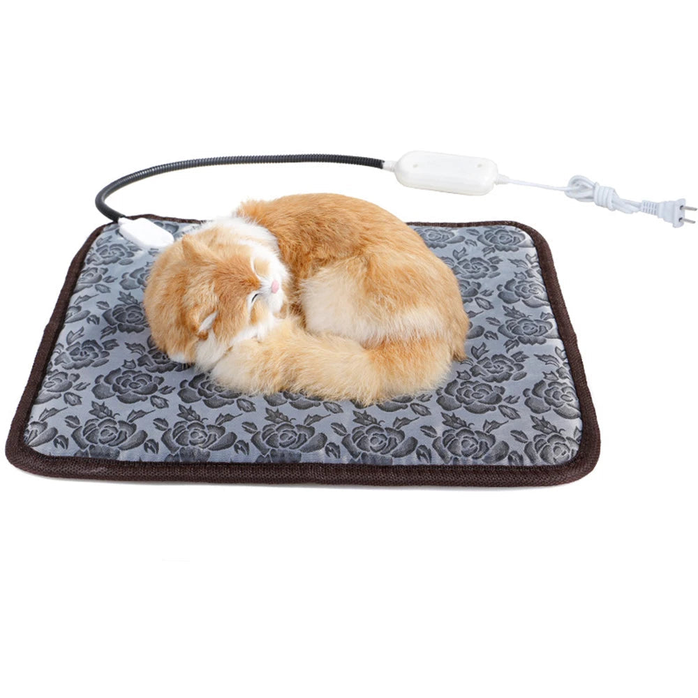 Orange and white cat sleeping on a grey floral electric heated pet mat with power cord and temperature controller