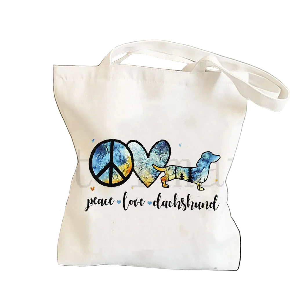 Cream canvas tote bag featuring a peace sign, heart and colourful Dachshund graphic with the words Peace Love Dachshund