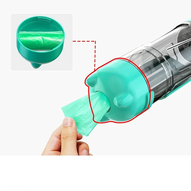 Turquoise portable dog water and food dispenser showing the built-in waste bag storage compartment and bag access opening