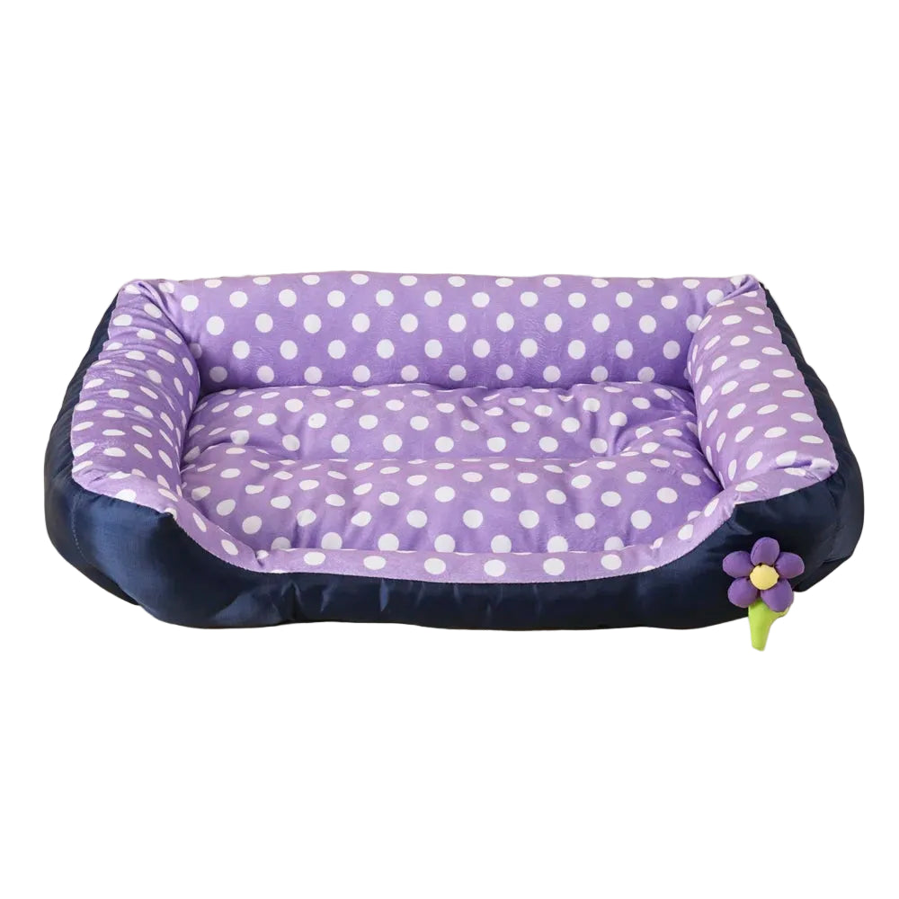 Purple polka dot bolster dog bed with padded base, raised cushioned sides and decorative flower detail