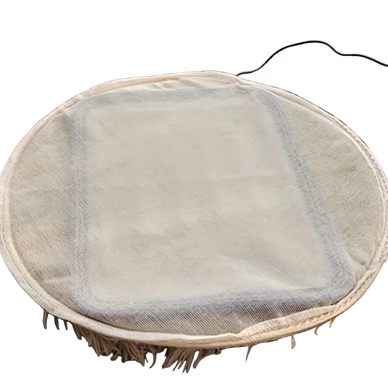 Round beige electric heated pet mat with soft fabric cover and attached power cord