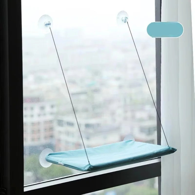 The hammock in light cyan, mounted on a window