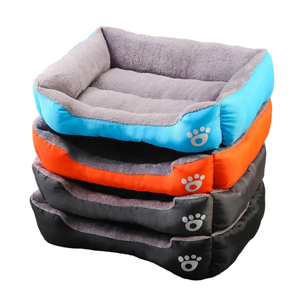 Stacked plush bolster dog beds in blue, orange, grey and black with soft lining and raised cushioned sides