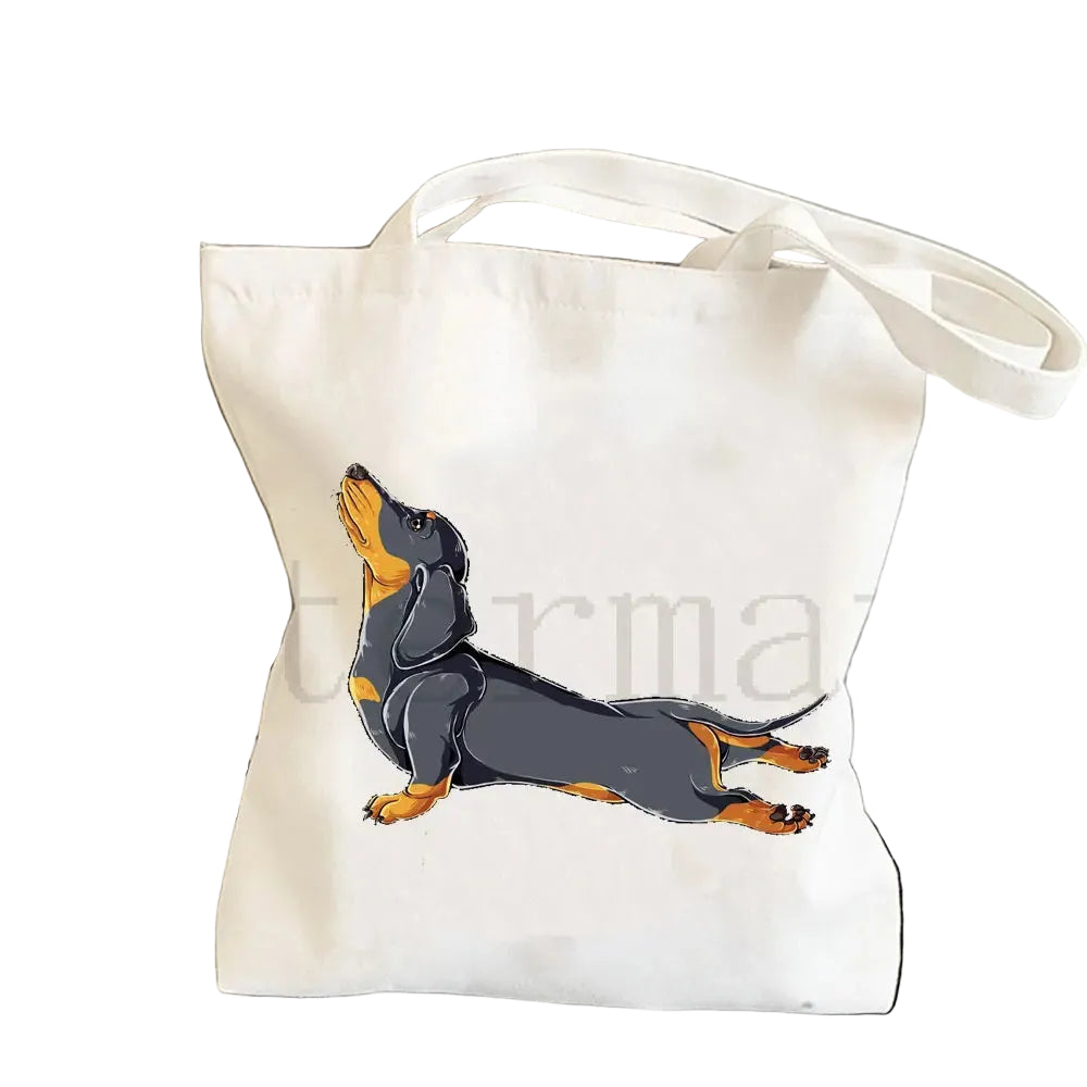 Cream canvas tote bag featuring a black and tan Dachshund stretching in a playful pose