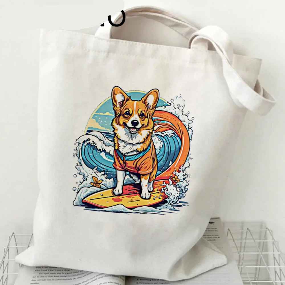 Cream canvas tote bag featuring a Corgi surfing on a wave in a colourful beach-style illustration