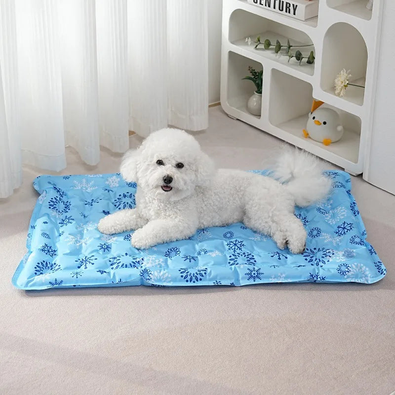 White fluffy dog lying on a blue snowflake print pet cooling mat indoors